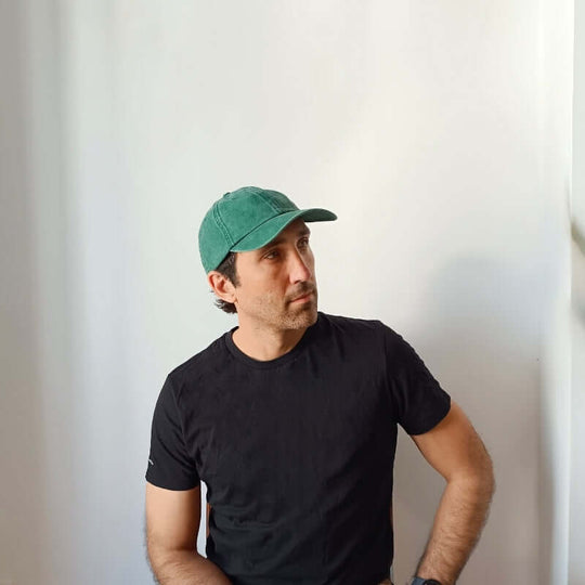 Model looking to the right wearing the Green Cotton Dad Hat by Free Heads. XL Cap for Large Heads.